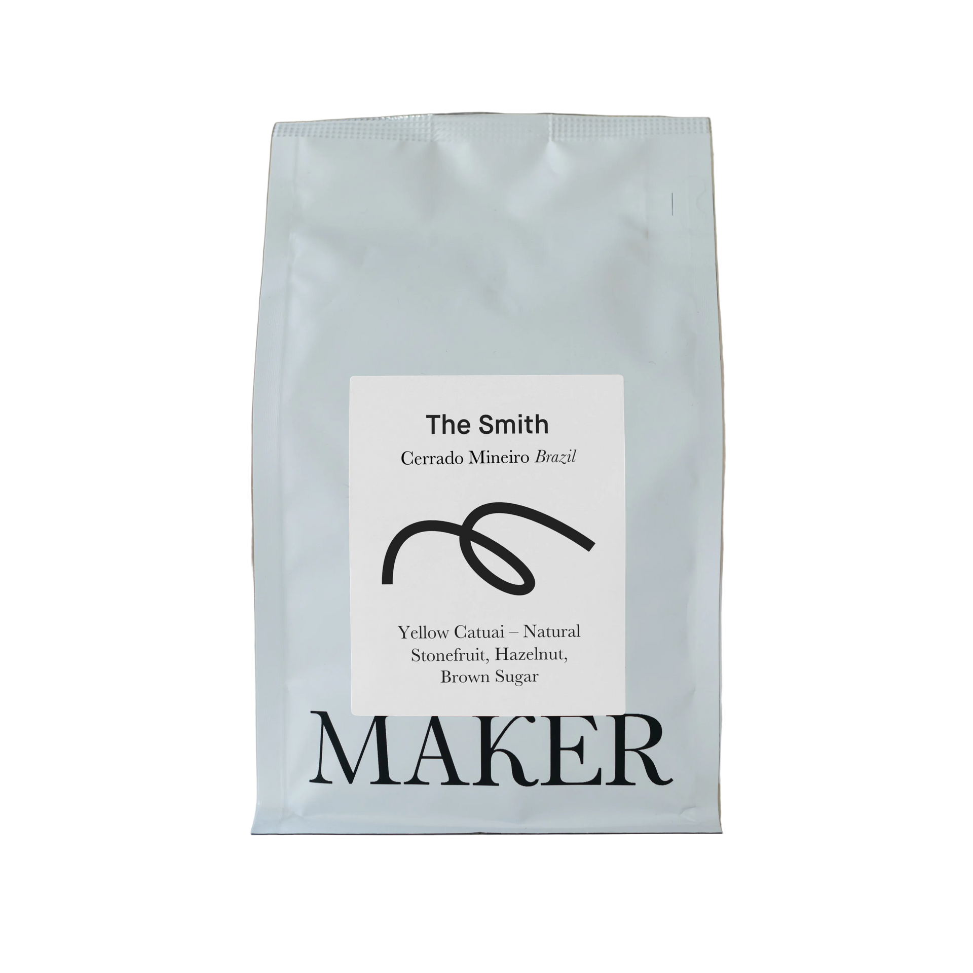 A white bag of coffee beans labeled 'The Smith' from Cerrado Mineiro Brazil, by Maker.