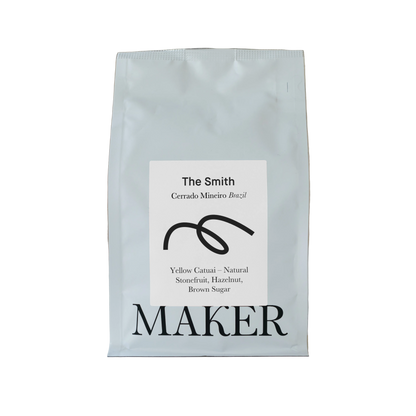 A white bag of coffee beans labeled 'The Smith' from Cerrado Mineiro Brazil, by Maker.