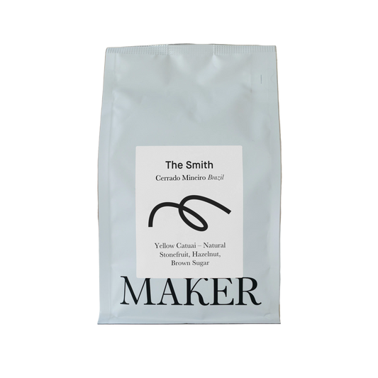 A white bag of coffee beans labeled 'The Smith' from Cerrado Mineiro Brazil, by Maker.